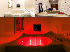a bathroom with a red bath tub and a sink at Hotel Mine (Love Hotel) in Kurume