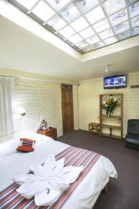 1 dormitorio con 1 cama blanca grande y tragaluz en Andean Dreams Hotel, en Cusco