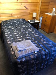een slaapkamer met een bed met handdoeken erop bij Travellers Retreat B&B in Christchurch