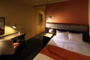 a hotel room with a bed and a television at Hotel Quest Shimizu in Shizuoka