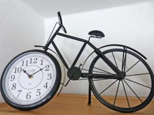 un reloj de bicicleta sentado sobre una mesa en Ferienwohnung *Hüs Pelle*, en Süddorf