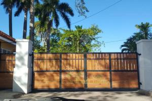 a wooden gate in front of a house with palm trees at MoBay Las Palmas in Montego Bay