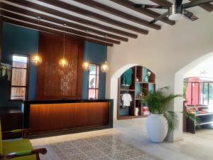 a lobby with a reception desk and a vase at Hotel Holly in Mérida