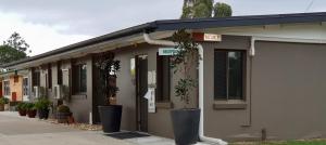 a building with potted plants sitting outside of it at Dalby Parkview Motel in Dalby