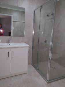 a bathroom with a shower, sink, and mirror at Dalby Parkview Motel in Dalby