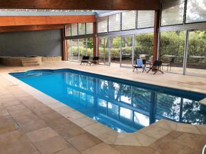 an indoor swimming pool with blue water in a house at Macedon Ranges Hotel & Spa in Macedon