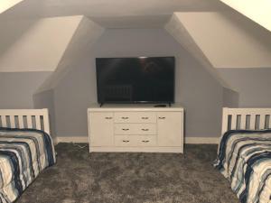 um quarto com duas camas e uma televisão numa cómoda em Blackberry Bunkhouse em Ashford