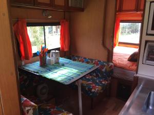 a small room with a table and a bed at LA MESETA DE TOMINE CAMPER in Sesquilé