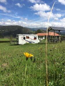 an rv parked in a field with a grassy field at LA MESETA DE TOMINE CAMPER in Sesquilé