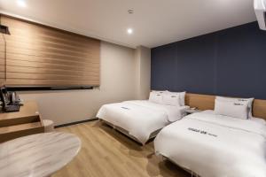a room with two beds and a desk at No.25 Hotel Busan Seomyeon Station in Busan