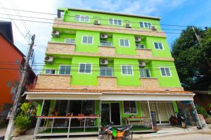 um edifício verde com uma scooter estacionada em frente em Lucky house Koh Tao em Ko Tao