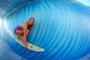 a woman riding a wave on a surfboard in a tunnel at Los Faroles Pacasmayo in Pacasmayo