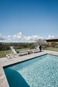 a swimming pool with two lounge chairs next to at 99 Acres Bangalow Retreat in Bangalow