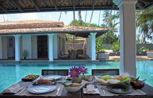 a table with food on it next to a pool at Era Beach in Unawatuna