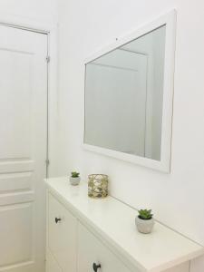 Baño blanco con espejo en una pared blanca en Le Fiche d’India, en Giuggianello