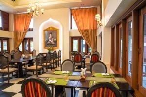 a restaurant with tables and chairs in a room at Le Palais Juliana Experience tradition on us Book 2 nights and get a free morning alms-giving session in Luang Prabang