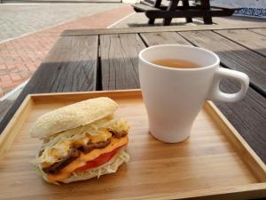 - un sandwich sur un plateau à côté d'une tasse de café dans l'établissement Matsu E19, à Nangan