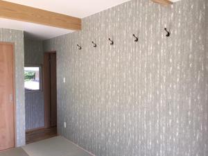 a room with a wall with a patterned wall at Guesthouse Kazenowa in Asahi