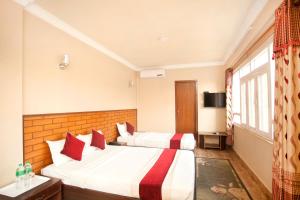 a hotel room with two beds and a window at Hotel Holiday Taj (p) Ltd in Kathmandu