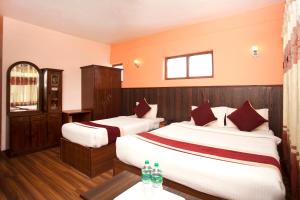 a hotel room with two beds with red pillows at Hotel Holiday Taj (p) Ltd in Kathmandu