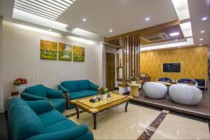 a living room with blue chairs and a table at Hotel Highgarden in Dhaka