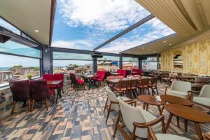 a restaurant with tables and chairs and large windows at Golden Sand Hotel in Istanbul