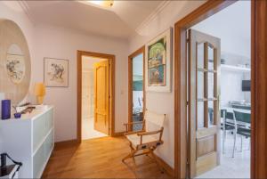 ein Wohnzimmer mit einem Stuhl und einem Tisch in der Unterkunft Ondarreta Beach & Terrace in San Sebastián