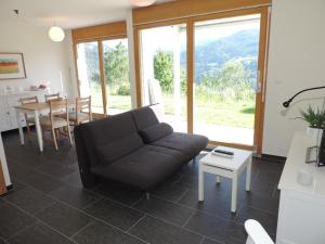 sala de estar con sofá y mesa en Alpenrose (295 Av), en Brienz