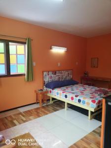 1 dormitorio con 1 cama en una habitación con paredes de color naranja en Bondoilampang en Ban Thung