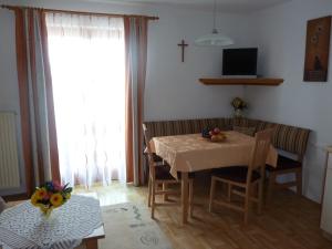 a dining room with a table and a cross on the wall at Gästehaus Sonnenhang in Mondsee