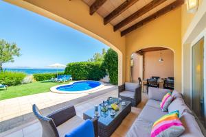 聖佩德羅科羅尼亞的住宿－S'EMBAT，一个带沙发和椅子的庭院和一个游泳池