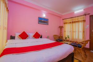 a bedroom with a large bed with pink walls at Sunrise Moon Beam Hotel in Nagarkot
