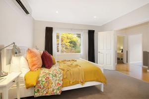 um quarto com uma cama com almofadas coloridas e uma janela em Clara Luce` em Bright
