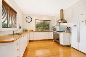 a kitchen with white cabinets and a clock on the wall at Clara Luce` in Bright