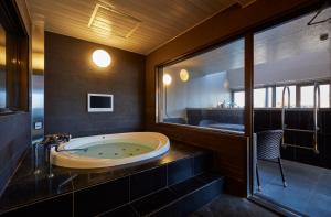 名古屋HOTEL LOVE的带浴缸和水槽的大浴室
