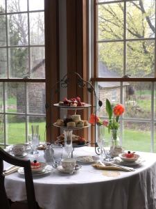 a table with a white table cloth and a plate of food at Harlem Stonegate B&B in Portland