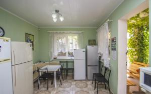 a kitchen with white appliances and a table and chairs at Solnechnaya 1109 in Zatoka