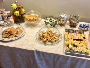 uma mesa coberta com pratos de comida e sobremesas em Hotel 5 Colonne em Mirano