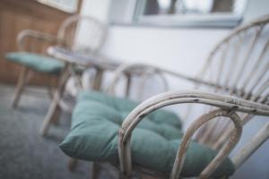 una silla con un cojín verde sentada junto a una mesa en Appartements Respiration Almhaus Pfister, en Predoi