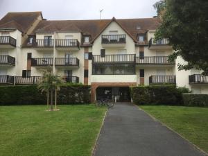 een gebouw met een fiets voor het gebouw bij Plage et Mer Service Tout Compris in Cabourg