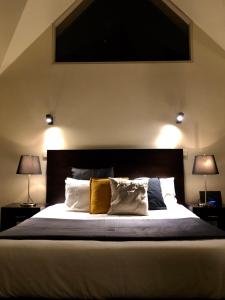 a bedroom with a large bed with two lamps at Lochiel Luxury Accommodation in Olinda