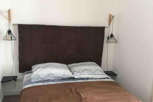 Una cama con dos almohadas y dos luces. en Zilarelle, en Ajaccio