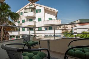 a balcony with a table and chairs and a building at Dobrljanin LUX apartment in Budva