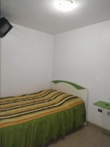 1 dormitorio con 1 cama en una habitación blanca en Hospedaje Harjeny en Trujillo