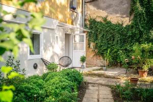 a white house with a white door and plants at Presso Pécs in Pécs