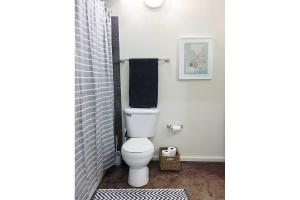 a bathroom with a white toilet and a black towel at City Loft w/ View of Gay St in Knoxville