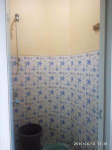 a bathroom with a toilet with blue flowers on the wall at Penginapan Hotel Mangir Asri in Giaoag