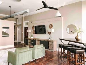 a living room with a table and chairs and a television at Cru Loft in the Heart of Downtown Knox in Knoxville