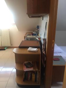 eine Küche mit einem Waschbecken und einem Regal mit Büchern in der Unterkunft Casa Fara Gino in Ascoli Piceno