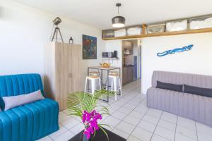 sala de estar con 2 sofás azules y cocina en Boucan Beach Joli studio vue mer à Boucan Canot en Boucan Canot